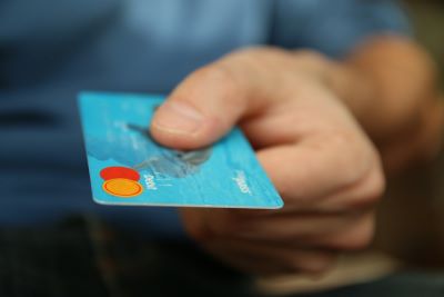 In einer Hand befindet sich eine Kreditkarte.