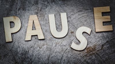 Das Wort Pause aus fünf Holz-Buchstaben geschrieben.